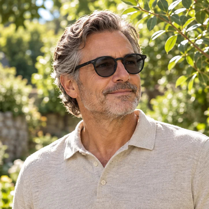 Man outdoors wearing lightly tinted round-frame glasses